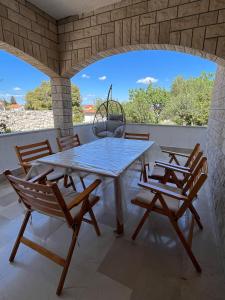a table and chairs on a patio with a view at ATJ house in Supetar