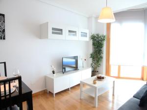 サントーニャにあるPrecioso apartamento en Santoñaのリビングルーム(ソファ、白いキャビネットのテレビ付)