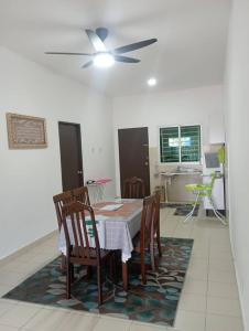 a dining room with a table and chairs and a ceiling fan at AA HOMESTAY TAWAU in Kampong Parit