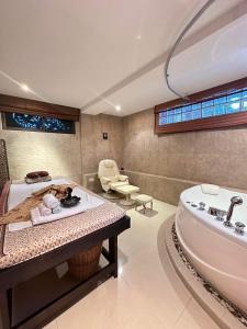 a bathroom with a tub and a sink and a bath tub at Talay Naiharn Hotel in Rawai Beach