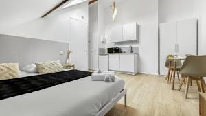 um quarto branco com uma cama e uma cozinha em Homey Cream - Joli Studio/Proche Vitam Parc em Viry