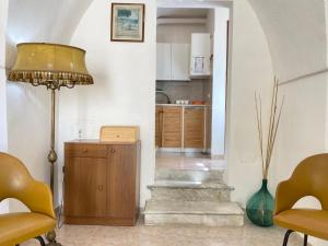 een woonkamer met een staande lamp en een keuken bij Casa Vacanze Lucie - Apulia Home in Sannicola +25 foto's