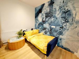 a bedroom with a yellow bed and a painting at Luxury modern new apartment with garden&free parking,close to Wroclaw self check-in 24h in Siechnice