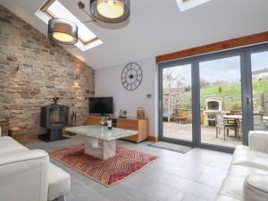 a living room with a fireplace and a stone wall at Jaycot in Alston