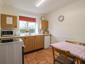 a kitchen with a table and a sink and a microwave at Blorenge in Abergavenny