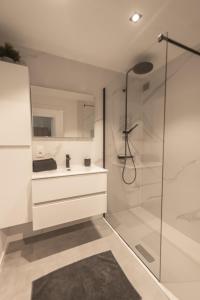 a white bathroom with a shower and a sink at Ostend Center Luxury Top Floor Apartment with Free Parking in Ostend