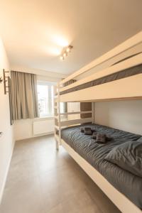 a bedroom with two bunk beds and a window at Ostend Center Luxury Top Floor Apartment with Free Parking in Ostend
