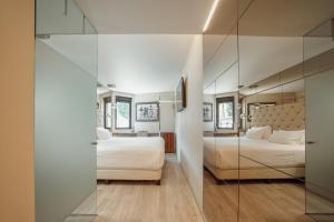 a hotel room with two beds and a mirror at ABC Hotel Porto - Boavista in Porto