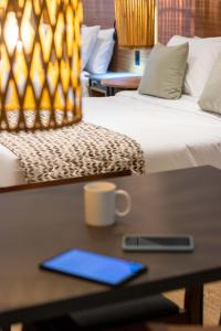 a desk with a blue tablet on a table next to two beds at Kastel Petrópolis in Petrópolis