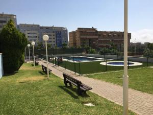 a park with benches and a pool in a city at Teatinos Atico Penthouse Pool WiFi Parking in Málaga
