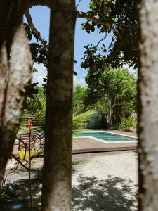 a swimming pool in a yard with trees at Pousada Refazenda in Corumbau