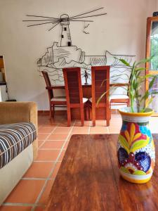 een woonkamer met een tafel en stoelen en een vaas bij La Posada Pacifica in Puerto Vallarta