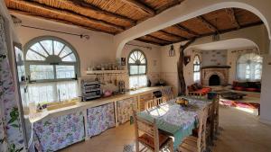 een grote keuken met een tafel en een open haard bij Dar Ez-zine in Ounara +54 foto's