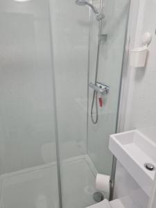 a shower with a glass door next to a sink at 1 Bed Annex 2 mins from Harlow Mill train station in Harlow