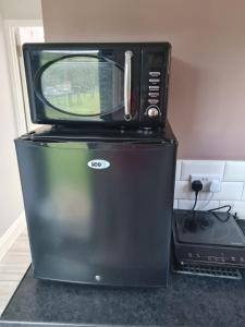 a microwave sitting on top of a refrigerator at 1 Bed Annex 2 mins from Harlow Mill train station in Harlow