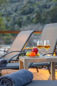 レティムノ・タウンにあるTraditional House with Private Poolのボート上のテーブルに置かれたワイン2杯とフルーツ