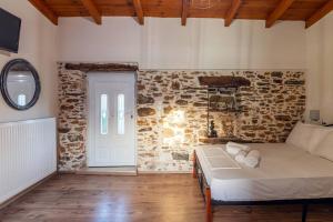 a bedroom with a bed and a stone wall at Traditional House with Private Pool in Rethymno