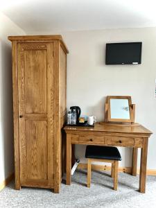 a wooden desk with a mirror and a wooden cabinet at The Crown Inn in West Down