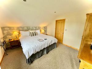 a bedroom with a large bed and a wooden door at The Crown Inn in West Down