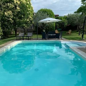 una grande piscina blu con ombrellone di Bed & Breakfast Bure Alto a San Pietro in Cariano