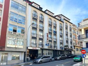 サンシェンショにあるHotel Florida Marの前に車が駐車されている大きな建物