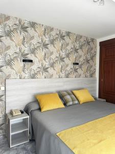 a bed with two yellow pillows in a bedroom at Hotel Florida Mar in Sanxenxo