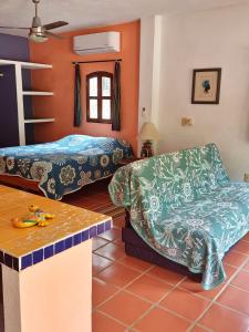 een kamer met 2 bedden, een bank en een tafel bij La Posada Pacifica in Puerto Vallarta