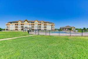 un edificio con una valla frente a un campo de césped en Lakefront Corsicana Condo with Pool Access!, en Corsicana