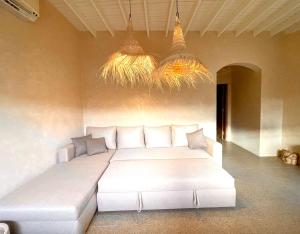 a large white bed in a room with two chandeliers at Mannam apartment boho in Dahab