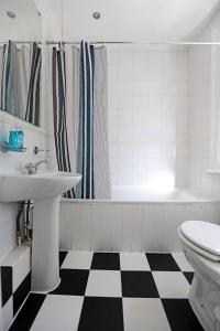 a bathroom with a black and white checkered floor at LORD MERIT GUEST HOUSE KING'S CROSS GRAYS INN ROAD in London