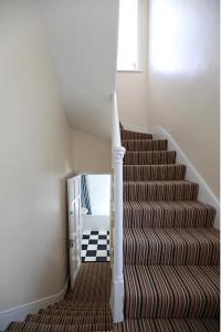 a stairway with a spiral staircase with a mirror at LORD MERIT GUEST HOUSE KING'S CROSS GRAYS INN ROAD in London
