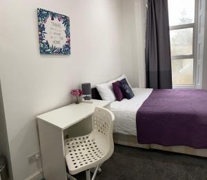 a bedroom with a bed and a desk and a table at LORD MERIT GUEST HOUSE KING'S CROSS GRAYS INN ROAD in London