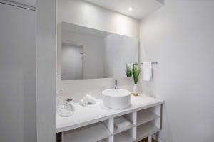 La salle de bains blanche est pourvue d'un lavabo et d'un miroir. dans l'établissement Upstay - Modern Suite w Pool - Mins From Disney, à Kissimmee
