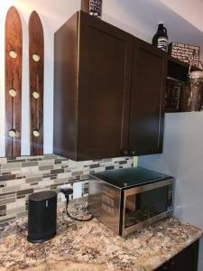 a kitchen with a counter with a microwave and snowboards at The Hidden Porch at Sir Sam's (hot tub & sauna) in Haliburton