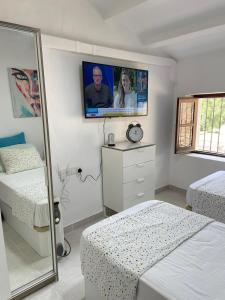 a bedroom with two beds and a tv on the wall at Captivating 3-Bed Villa in Antas in Antas