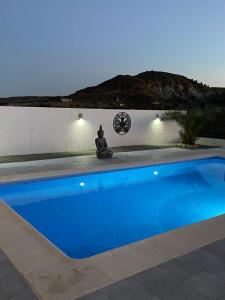 a blue swimming pool with a clock on a wall at Captivating 3-Bed Villa in Antas in Antas