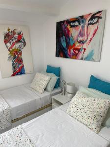 a bedroom with two beds and a painting on the wall at Captivating 3-Bed Villa in Antas in Antas