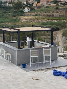 a concrete bar with three stools at Captivating 3-Bed Villa in Antas in Antas