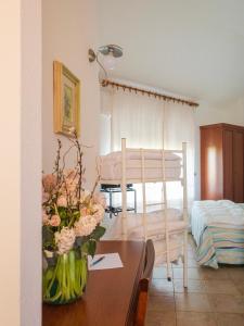 a living room with a table with a vase of flowers at Hotel Donatella in Posada