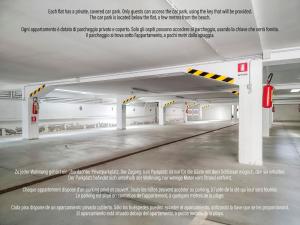 an empty parking garage with a sign on the wall at Jesolo Sun Beach House - Host Solution in Lido di Jesolo