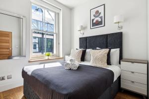 a bedroom with a large bed with two towels on it at Fitzrovia 3BR - CityApartmentStay in London
