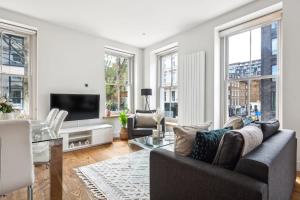 a living room with a couch and a tv at Fitzrovia 3BR - CityApartmentStay in London