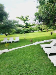 a group of white benches sitting in a park at Serenity Nhabanga, Bilene in Nhabanga