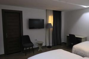 um quarto de hotel com uma cama e uma televisão na parede em elhosary motel em Cidade 6 de Outubro