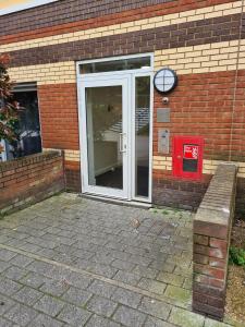 a door of a brick building with a bench in front at North Greenwhich Homestay in London