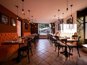 a restaurant with tables and chairs in a room at Maison d'Hôtes Les Sources in Villedieu