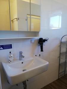 uma casa de banho com um lavatório branco e um espelho. em 3611 HAUS HABRUCK Top 2 em Habruck