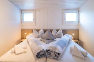 a large bed in a room with two windows at Hotel Weinberg in Appiano sulla Strada del Vino