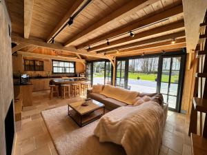 a living room with a couch and a table at Magnifique chalet en bois avec piscine et jacuzzi in Court-Saint-Étienne