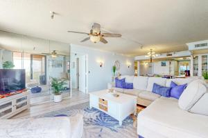 a living room with a white couch and a tv at Sunset Shores in St. Pete Beach